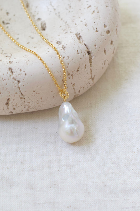 Pearl necklace on a white stone surface