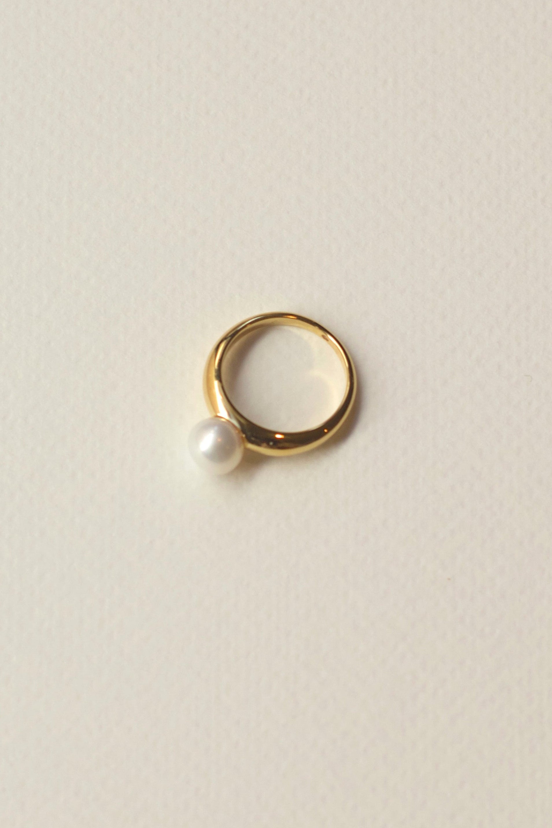 Pearl gold ring on neutral background